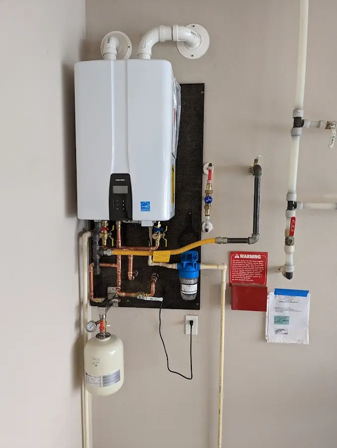 Professional plumber installing copper piping in a South Lyon home